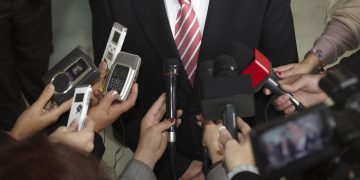 close up of conference meeting microphones and businessman